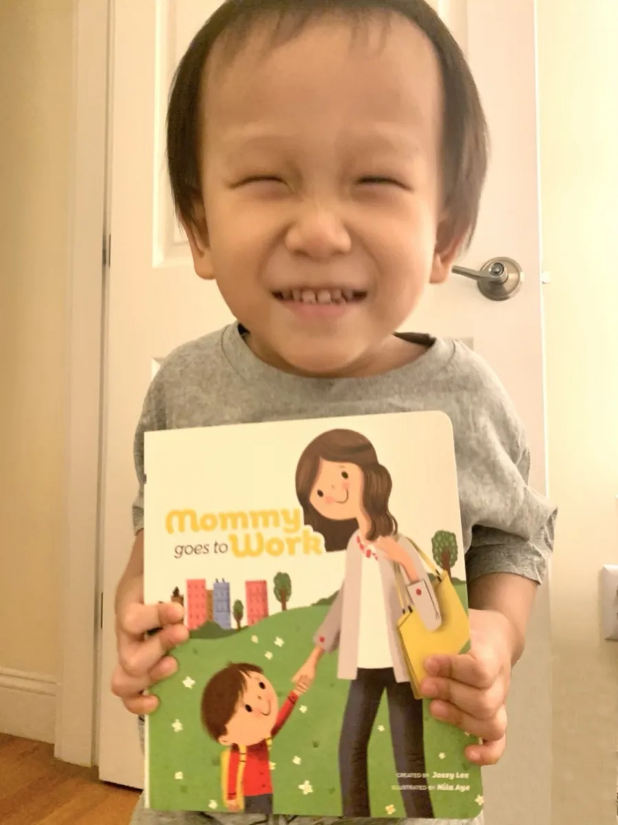 A boy grinning behind the book